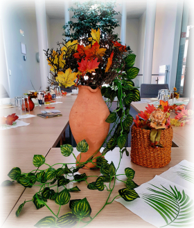 Herbstlicher Tisch sowie in der Mitte Tonvase mit Zweigen, Ahornblättern und Ranken